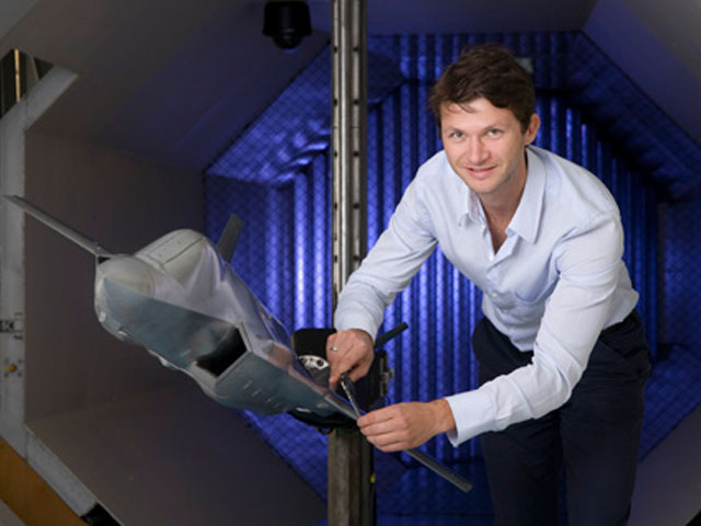 DSTG scientist in the Low Speed Wind Tunnel with a model plane.