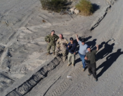 Bin Lee (centre) with four DRDC colleagues testing the new CADPAT (MT) uniform and other developmental materials at 29 Palms, California in November 2022.The Marine Corps Air Ground Combat Center (MCAGCC), also known as 29 Palms, is the largest United States Marine Corps base.